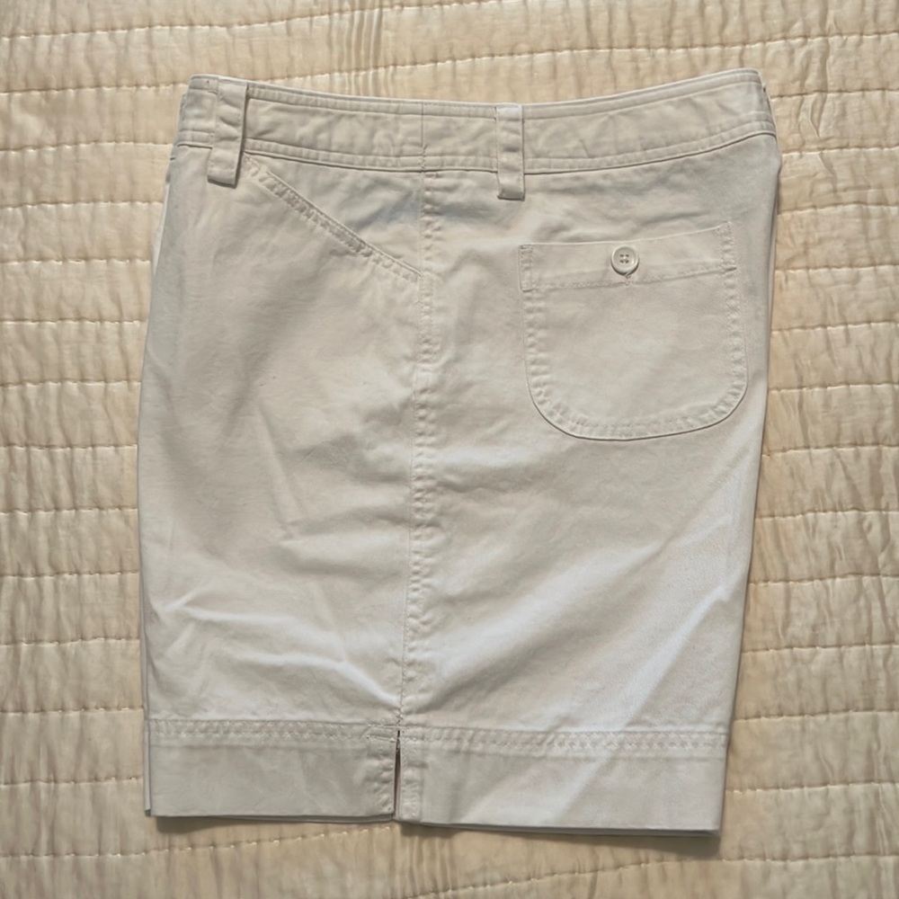 White shorts. 7 in inseam. Pockets on back with buttons.